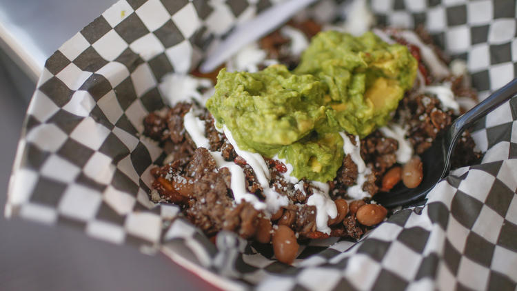 The Patacon, a fried plantain tostada topped with beans, farmer's cheese, fresh guacamole and angus beef, at Cali Fresh.